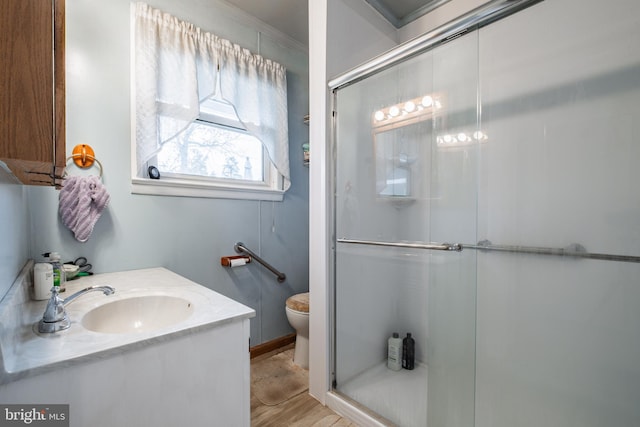 bathroom featuring wood-type flooring, vanity, toilet, and walk in shower