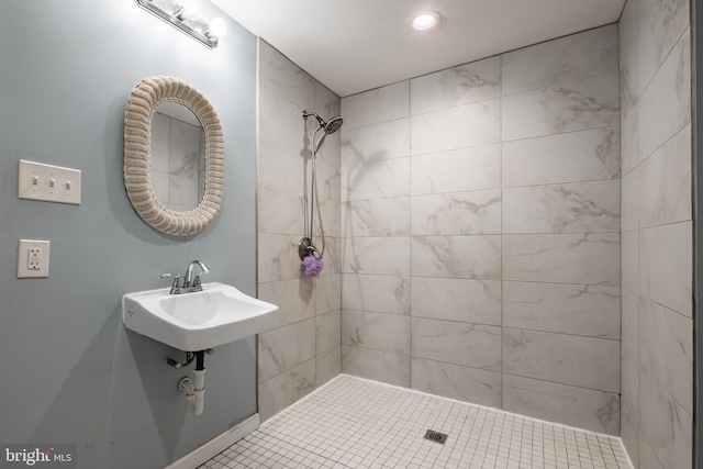 bathroom featuring a tile shower, tile patterned floors, and sink