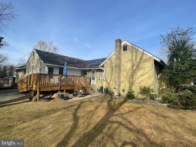 rear view of house featuring a yard and a wooden deck