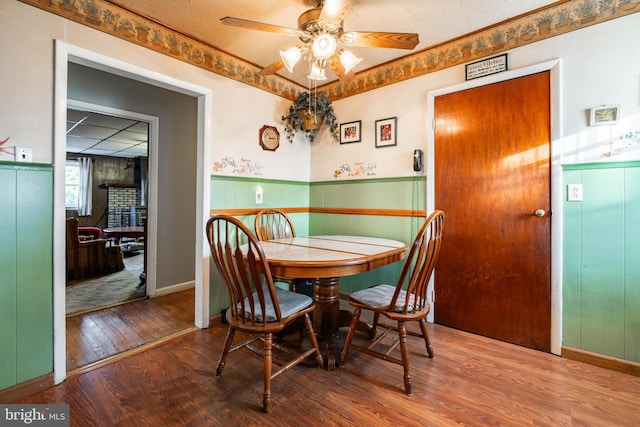 dining area with ceiling fan and wood-type flooring