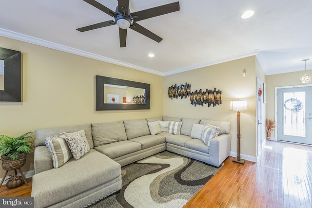 living room featuring ceiling fan, ornamental molding, and hardwood / wood-style flooring