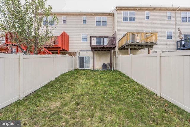 back of house with a lawn, cooling unit, and a wooden deck