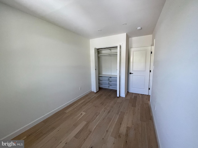 unfurnished bedroom with a closet and light hardwood / wood-style flooring