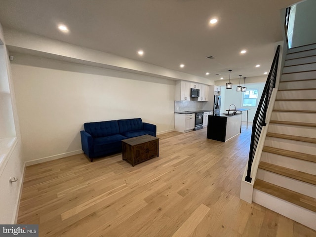 living room featuring light wood-type flooring and sink