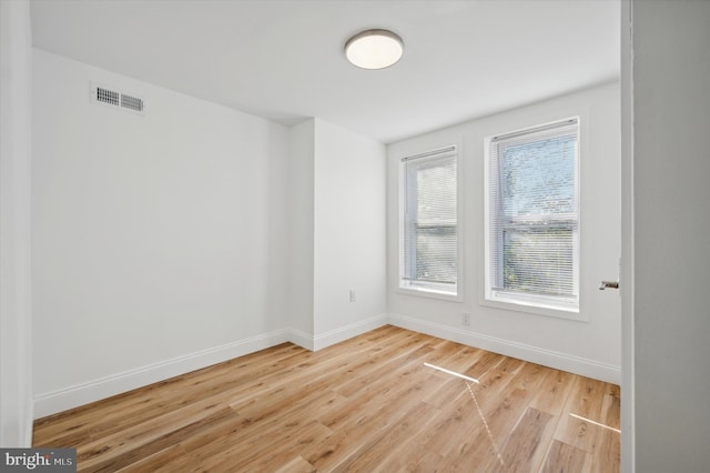 unfurnished room with light wood-type flooring and a wealth of natural light