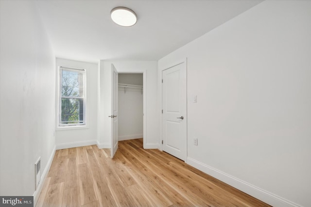 unfurnished bedroom with light hardwood / wood-style floors and a closet