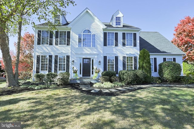 colonial home featuring a front yard