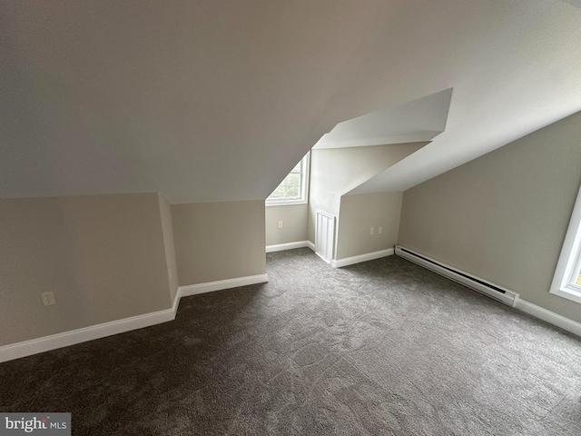 bonus room featuring dark colored carpet, baseboard heating, and lofted ceiling