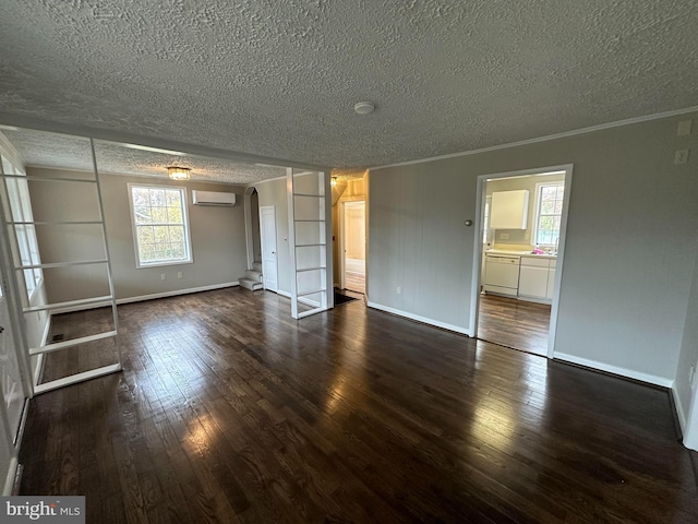 interior space featuring a textured ceiling, crown molding, dark wood-type flooring, and a wall mounted air conditioner