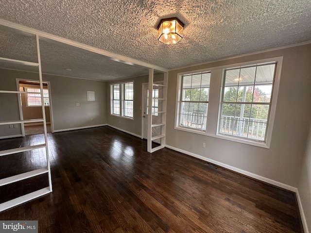 unfurnished room featuring a textured ceiling, dark wood-type flooring, and a wealth of natural light