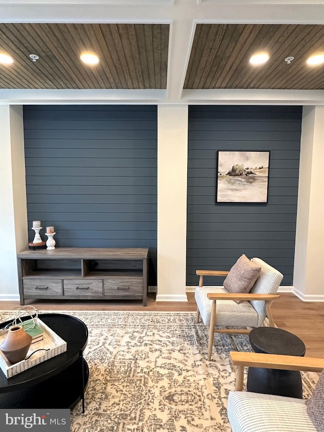 living room with light hardwood / wood-style floors and wood walls