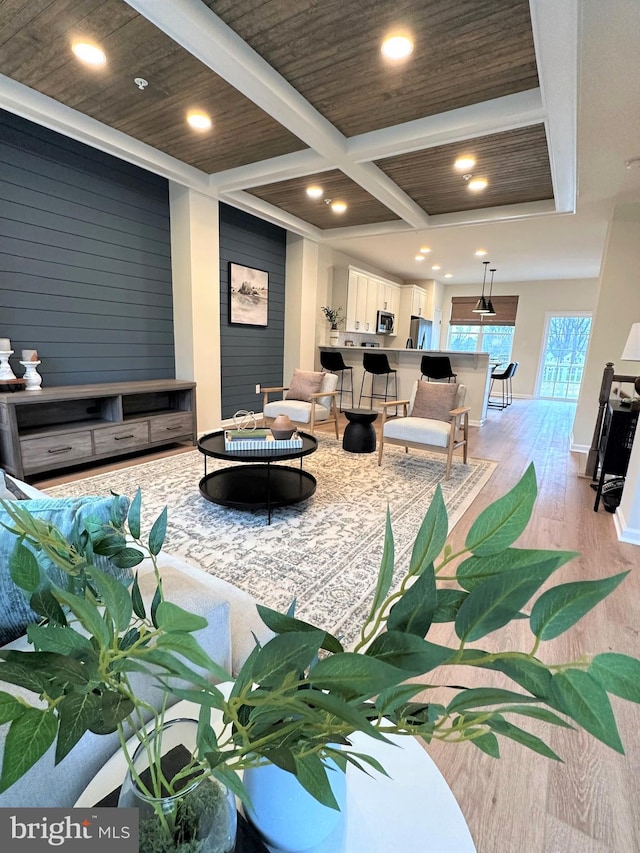 living room featuring light hardwood / wood-style floors, beam ceiling, and coffered ceiling