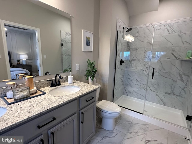 bathroom featuring a shower with door, vanity, and toilet