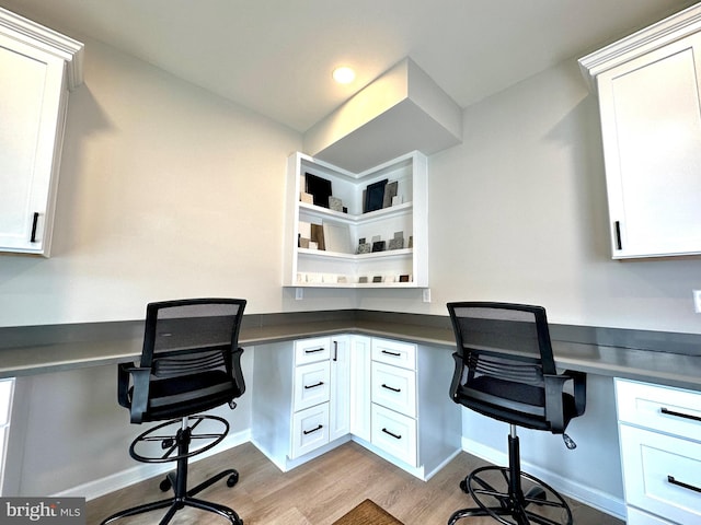 office area with built in desk and light wood-type flooring