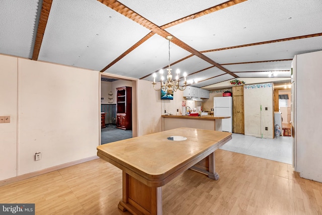 dining space featuring light wood-type flooring and lofted ceiling with beams