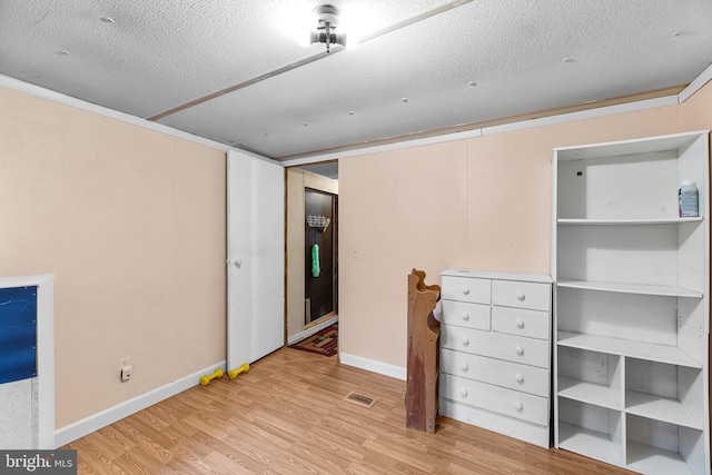 unfurnished bedroom featuring a textured ceiling and light hardwood / wood-style flooring