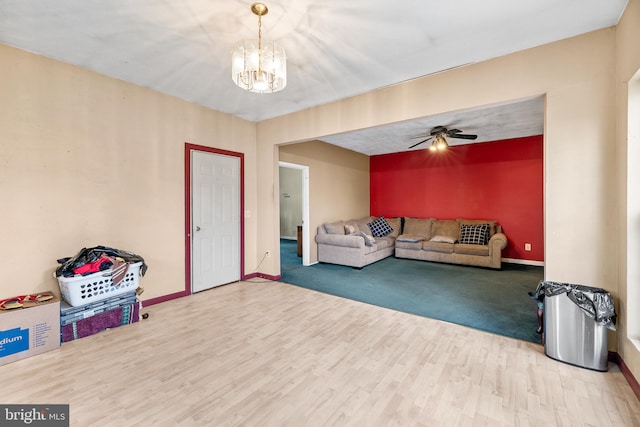 living room featuring hardwood / wood-style floors and ceiling fan with notable chandelier