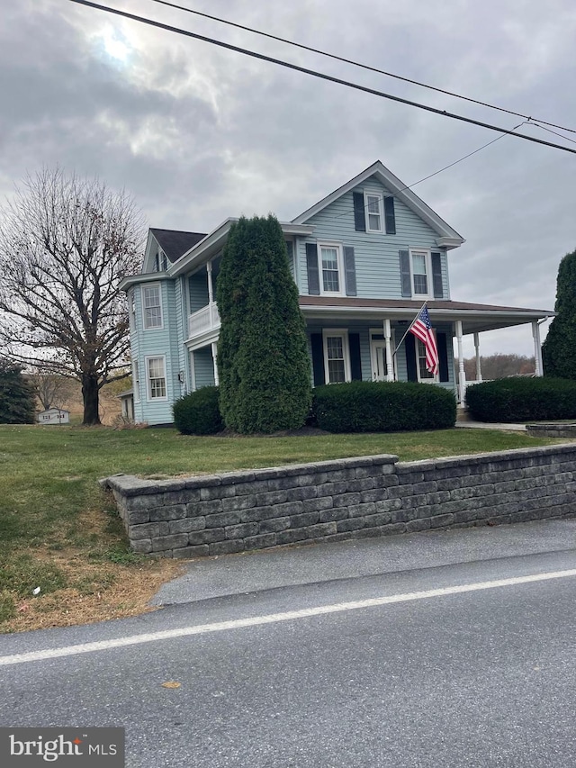 view of front facade with covered porch and a front yard