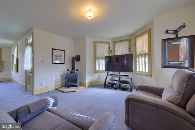 carpeted living room with a wood stove