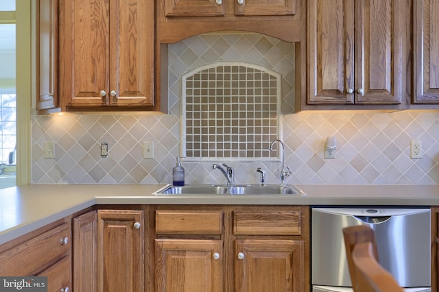 kitchen featuring stainless steel dishwasher, sink, and backsplash