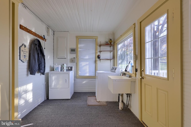 washroom with washer and clothes dryer, dark carpet, brick wall, and sink