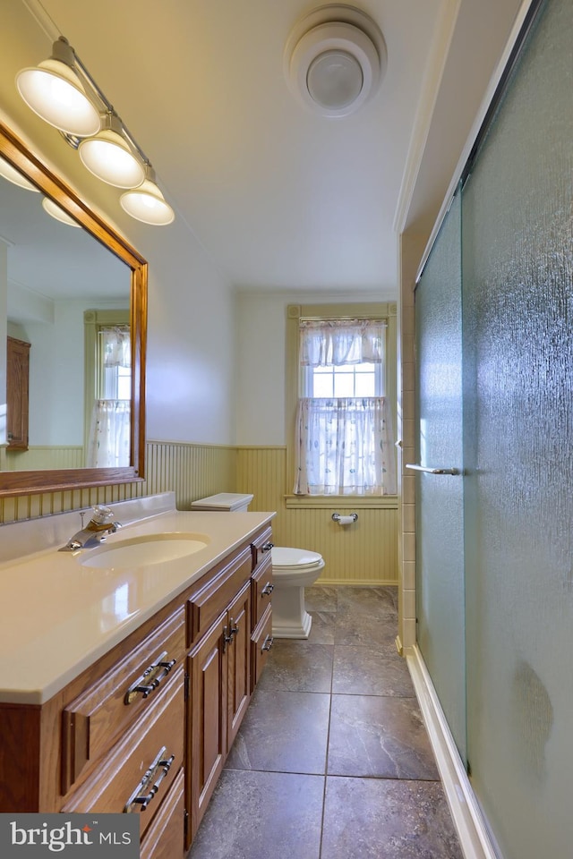 bathroom with vanity, a shower with shower door, and toilet