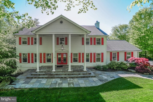 rear view of property with french doors and a yard