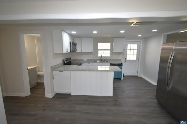 kitchen featuring sink, dark hardwood / wood-style floors, light stone countertops, white cabinetry, and stainless steel appliances