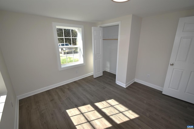 unfurnished bedroom featuring dark hardwood / wood-style floors and a closet