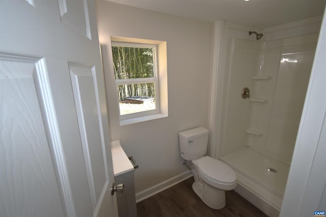 bathroom featuring a shower, wood-type flooring, vanity, and toilet