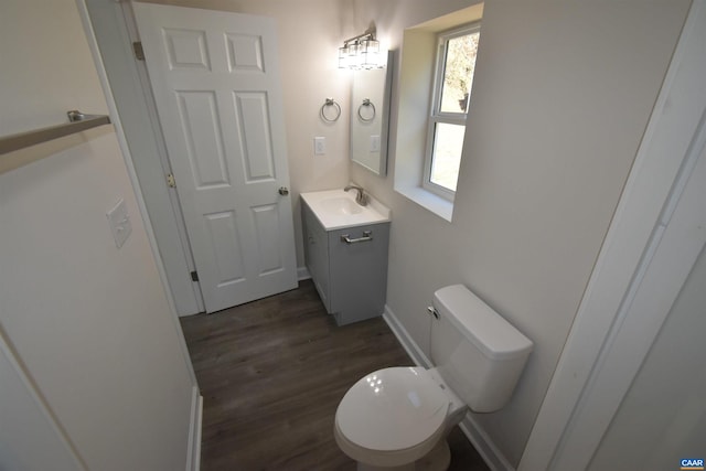 bathroom featuring toilet, vanity, and hardwood / wood-style flooring