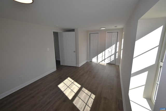 unfurnished room with dark hardwood / wood-style flooring