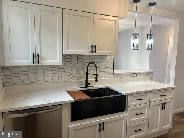 kitchen featuring dark hardwood / wood-style flooring, tasteful backsplash, white cabinets, dishwasher, and hanging light fixtures