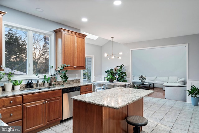 kitchen featuring dishwasher, a center island, an inviting chandelier, light stone countertops, and decorative light fixtures