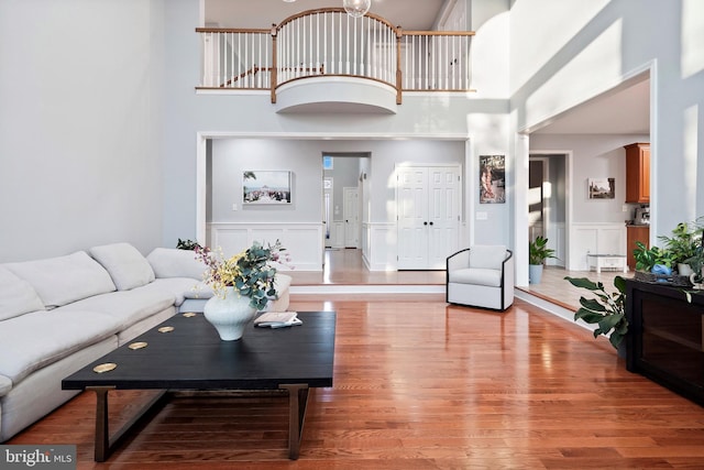 living room with light hardwood / wood-style floors and a high ceiling