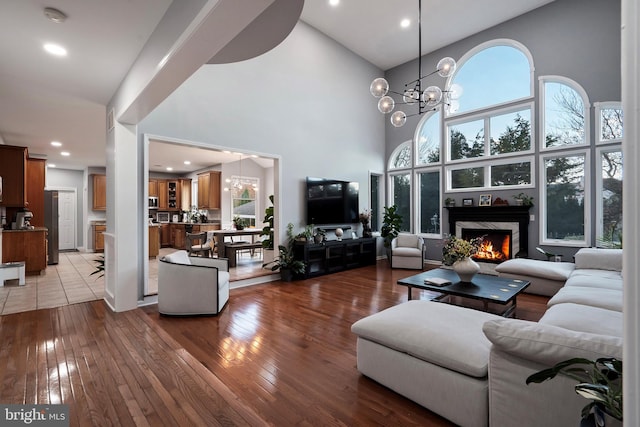 living room with a fireplace, hardwood / wood-style floors, a towering ceiling, and a wealth of natural light