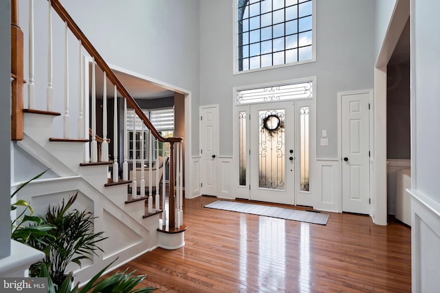 entrance foyer with wood-type flooring and a high ceiling