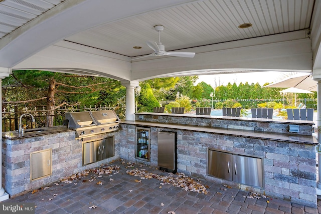 view of patio / terrace with ceiling fan, exterior kitchen, sink, and grilling area