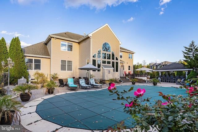 back of house with a patio and a covered pool