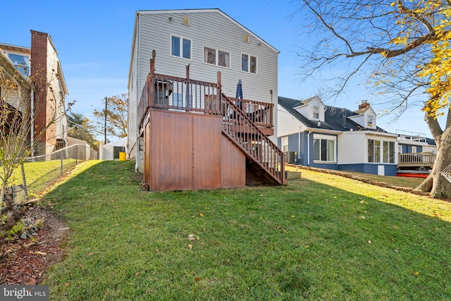 rear view of property with central AC unit, a deck, and a yard