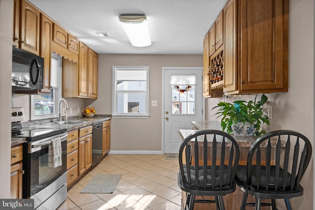 kitchen featuring light tile patterned floors, sink, and black appliances