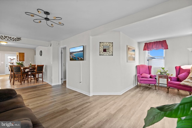 living room with an inviting chandelier and light wood-type flooring