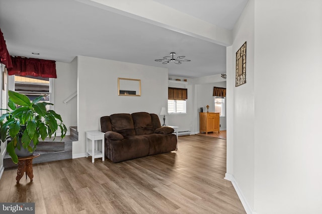 living room featuring ceiling fan, light hardwood / wood-style floors, and a baseboard radiator