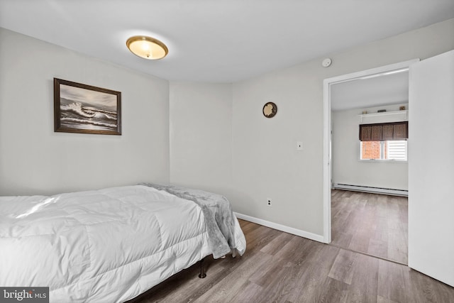 bedroom featuring hardwood / wood-style flooring and baseboard heating