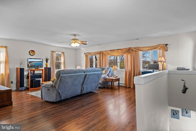 living room featuring ceiling fan, dark wood-type flooring, and a baseboard heating unit