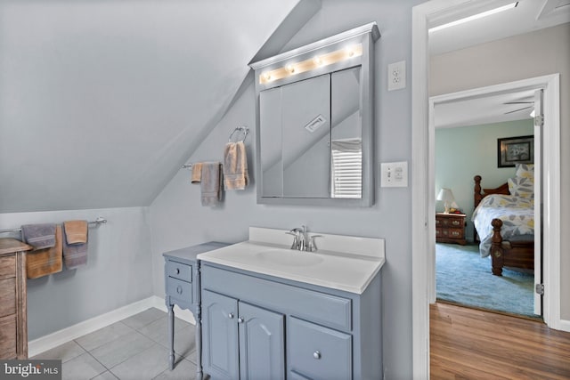 bathroom with hardwood / wood-style floors, vanity, ceiling fan, and lofted ceiling