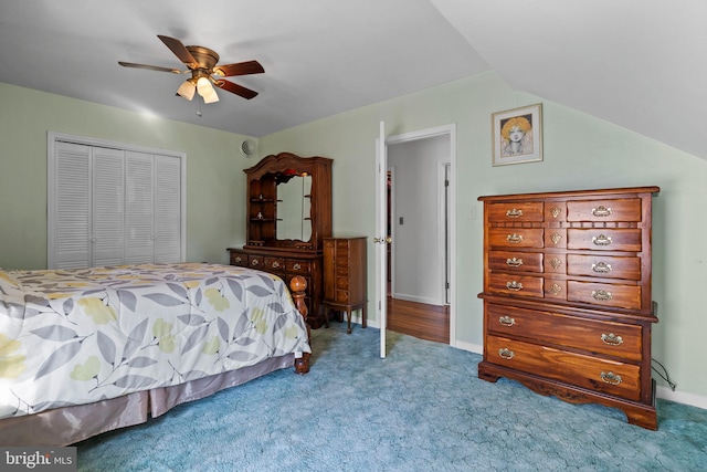 carpeted bedroom with ceiling fan, lofted ceiling, and a closet