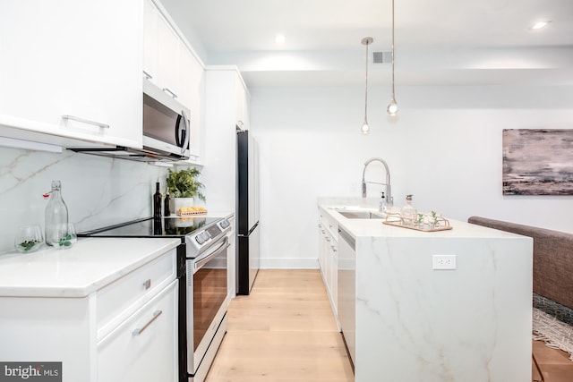 kitchen featuring pendant lighting, stainless steel appliances, white cabinetry, and sink