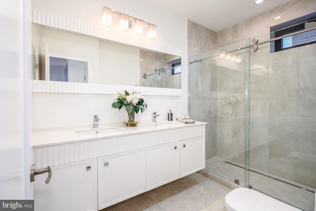 bathroom featuring tile patterned flooring, vanity, a shower with shower door, and toilet