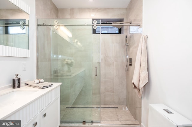 bathroom featuring vanity, toilet, and a shower with door